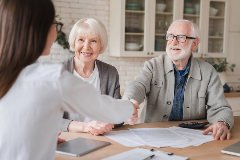 Husband and wife happily shake hands with their choice of best home care provider.