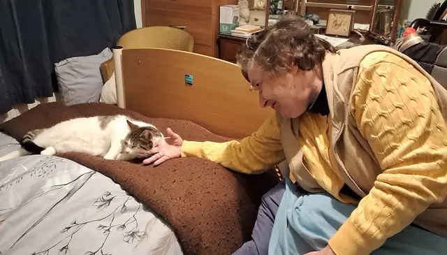 Helen with her cat on the anniversary of 25 years with Christies Care